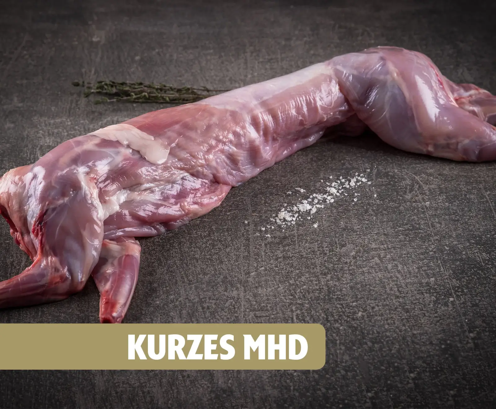 Ein roher, ausgenommener Kaninchen- oder Hasenkörper liegt auf einer dunklen Oberfläche, daneben Thymianzweige und Salzkristalle. Ein Banner mit "KURZES MHD" ist unten sichtbar.