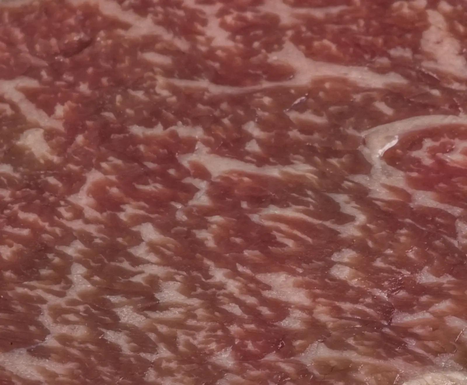 Nahaufnahme von rohem Hackfleisch mit marmorierter Textur und hellrosa Farbe