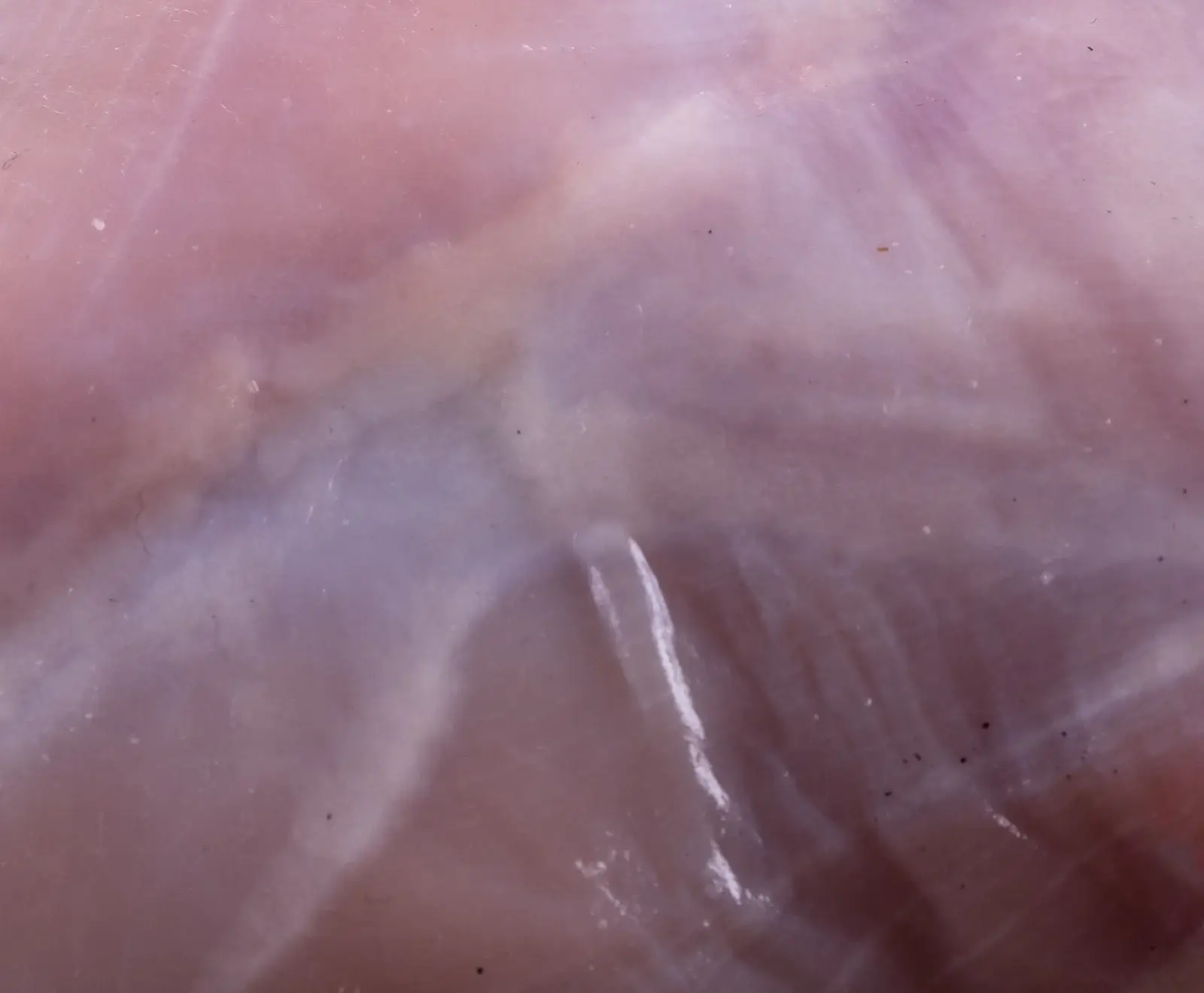 Abstrakte rosa Wolken mit weißen Schlieren und Strudeln auf einem violetten Hintergrund.