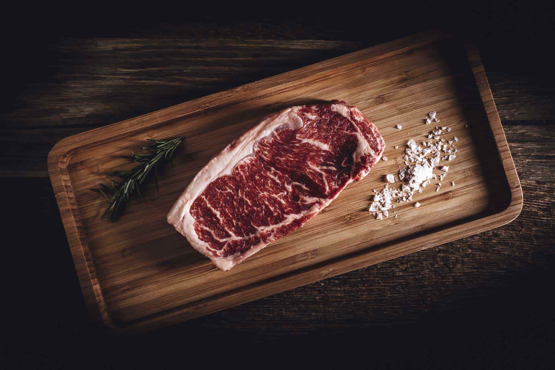 Rohes Stück Fleisch auf einem Brettchen liegend.