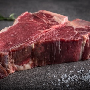 Rohes T-Bone Steak auf grauem Hintergrund