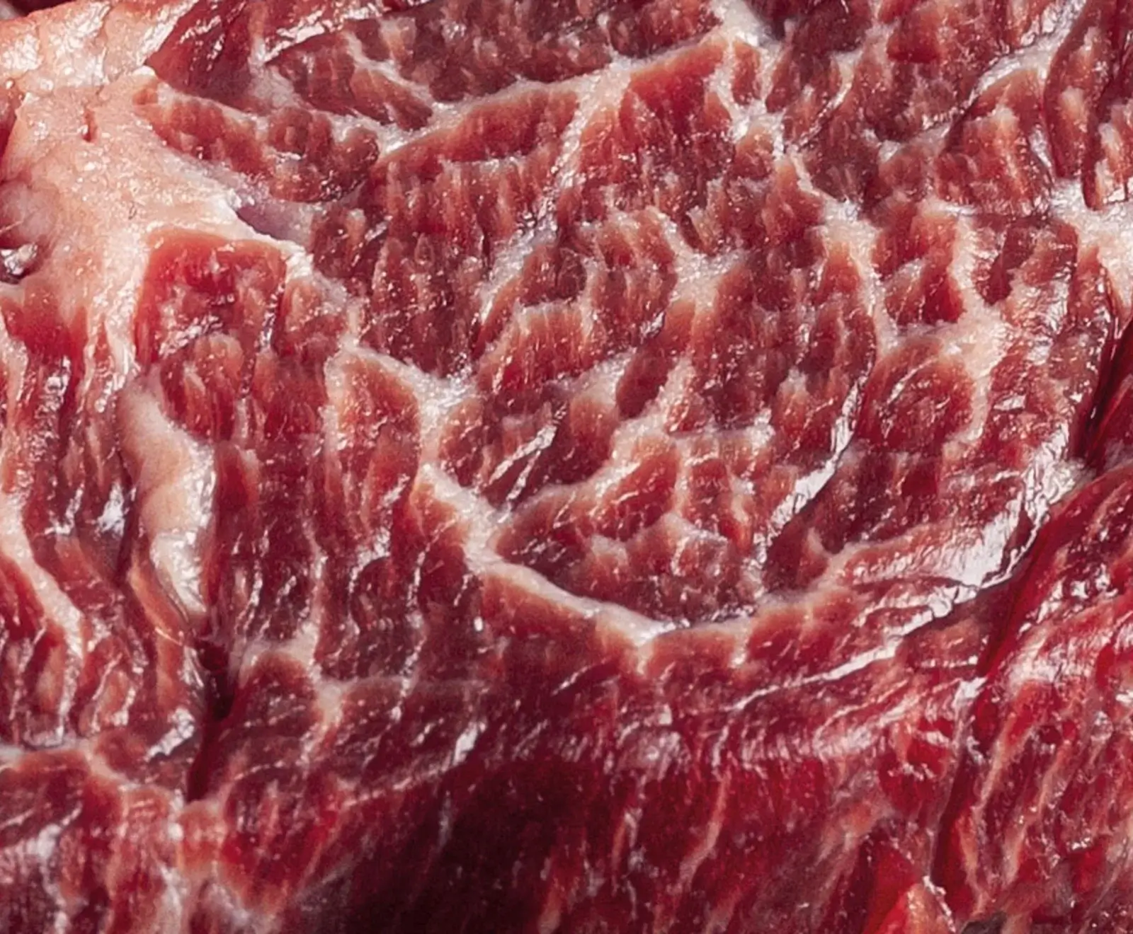 Nahaufnahme von rohem marmoriertem Fleisch mit Fettadern in Rottönen