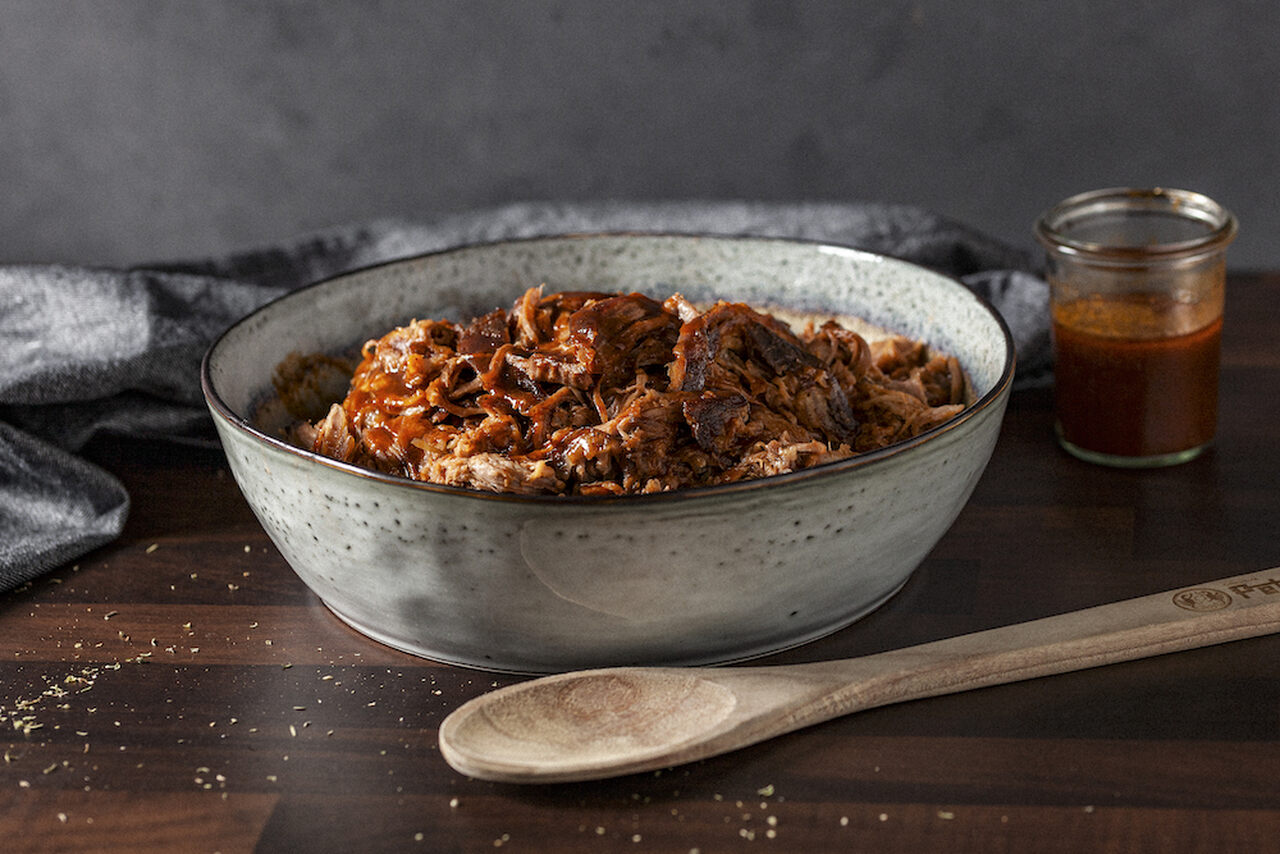 Pulled Pork in einer Schüssel mit Holzlöffel.