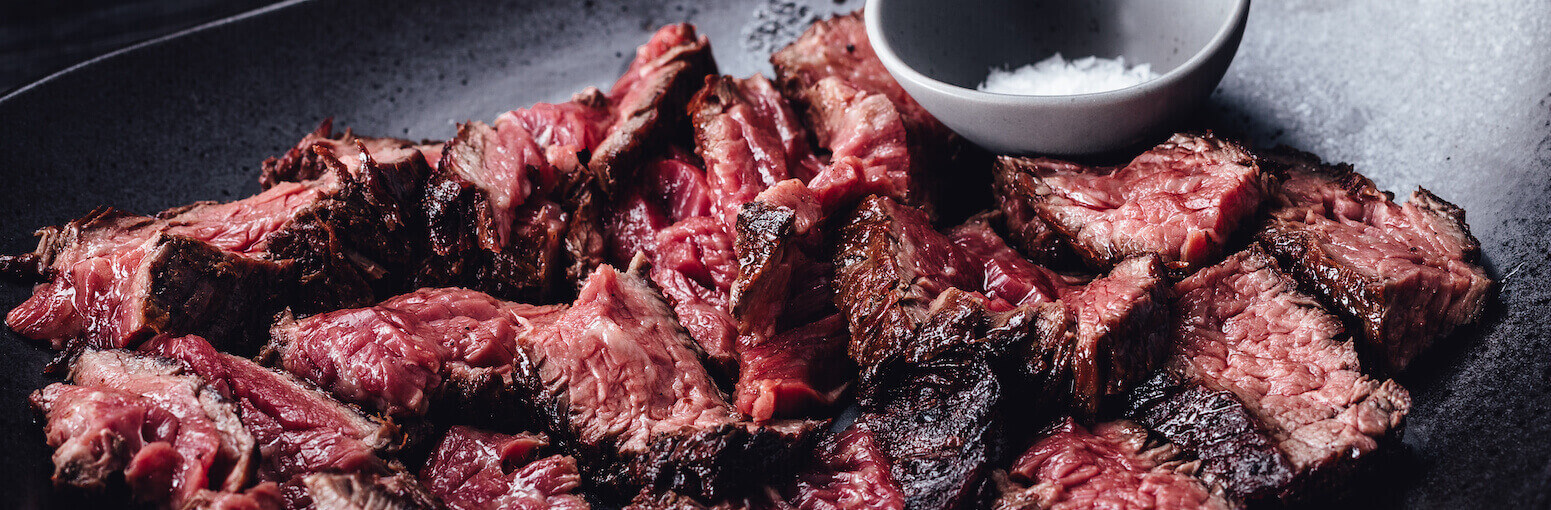 Teller mit tranchierten Steak-Streifen und Salz