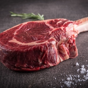 Rohes Tomahawk Steak auf grauem Hintergrund