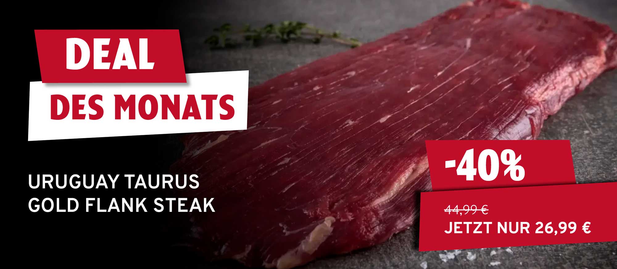 Ein rohes Uruguay Taurus Gold Flank Steak auf dunklem Untergrund mit Kräutern. Links oben steht "DEAL DES MONATS", rechts unten "-40%" und "44,99€ JETZT NUR 26,99 €".
