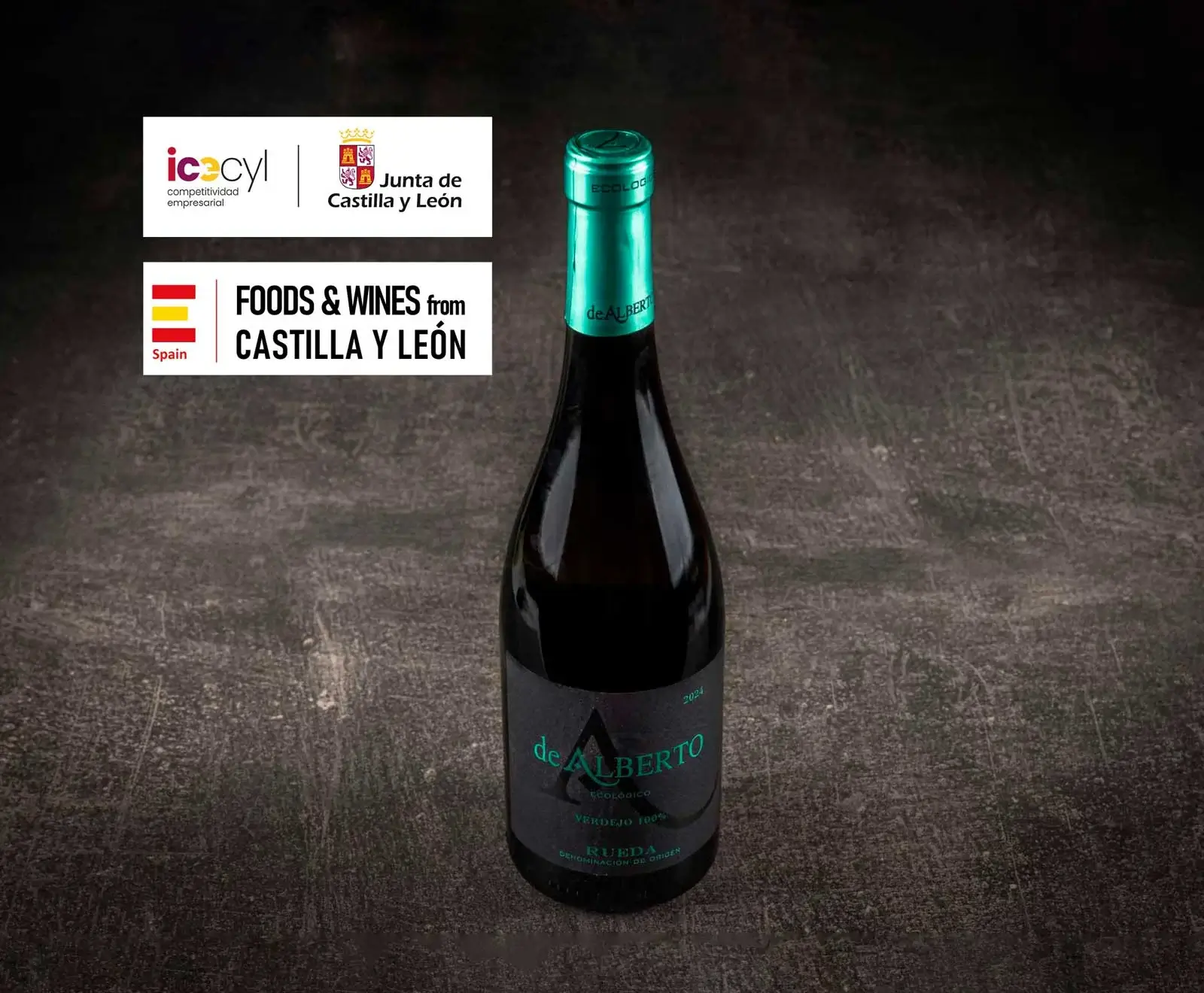 Eine Flasche de ALBERTO Verdejo 100% ökologischer Rueda Wein auf dunklem Hintergrund. Oben links sind Logos von Castilla y León und "Foods & Wines from Castilla y León" zu sehen.