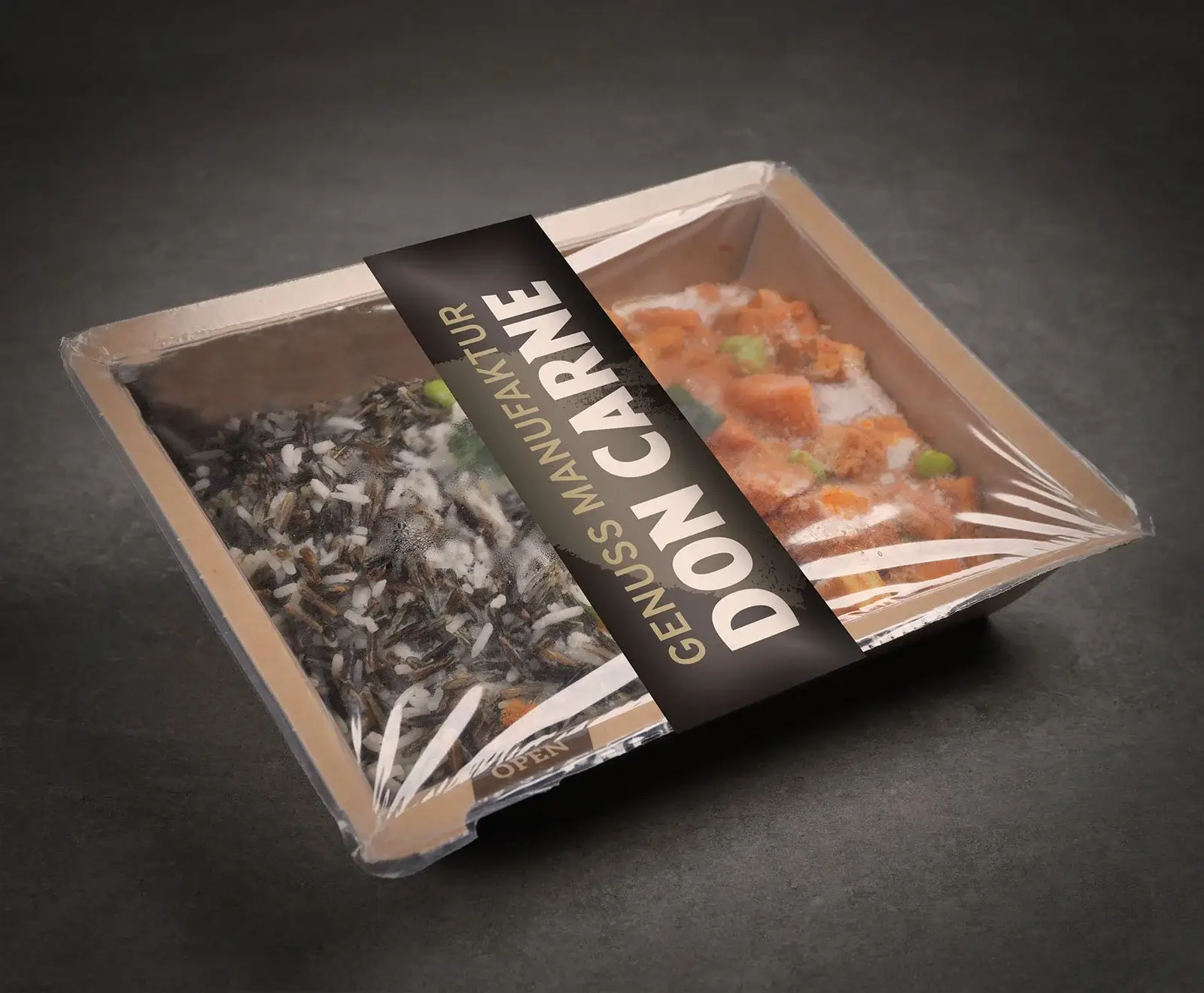 Eine Fertigmahlzeit in einer braunen Kartonschale, von oben betrachtet. Die Schale ist in zwei Fächer unterteilt: links ein Wildreis-Mix, rechts ein Gericht mit orangefarbenen Stücken und Sauce. Ein schwarzes Etikett mit "DON CARNE" und "GENUSS MANUFAKT